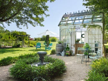 glass garden house with a fountain out front