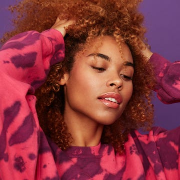 woman in tie dye sweatshirt with tinted lip balm