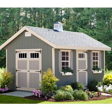 tiny cottage with flower beds surrounding and large double doors