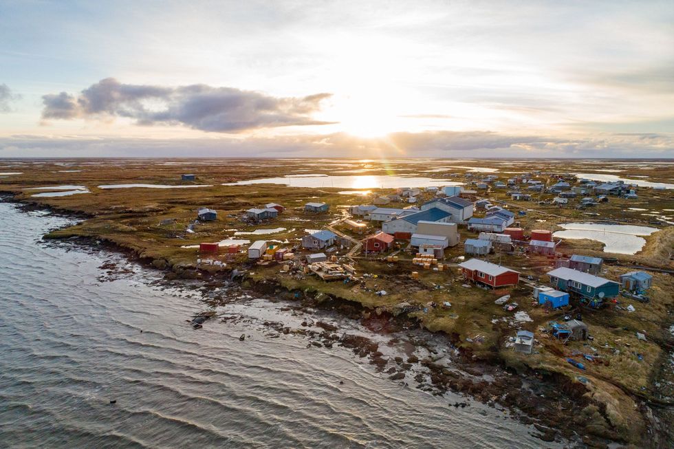 Er zitten nog maar enkele tientallen meters tussen de afkalvende permafrostkliffen in Newtok aan de Ninglick River dicht bij de Beringzee en de huizen Het hele dorp gaat verhuizen naar een nieuwe plek vijftien kilometer stroomop waarts Mogelijk moeten veel dorpen in Alaska hun voorbeeld volgen