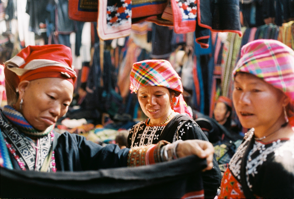 Vrouwen van de Rode Bao een van de tientallenminderheidsgroepen in het noorden van Vietnam bezoeken de markt van Sa Pa