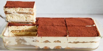 ladyfingers soaked in coffee layered with cream topped with a dusting of cocoa powder