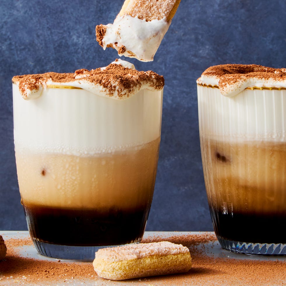 white russian cocktail topped with whipped cream, cocoa powder, and a lady finger