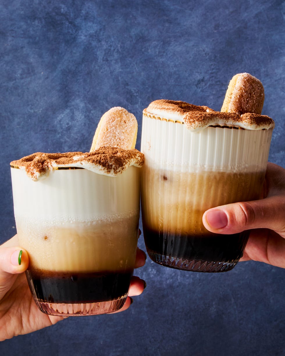 white russian cocktail topped with whipped cream, cocoa powder, and a lady finger