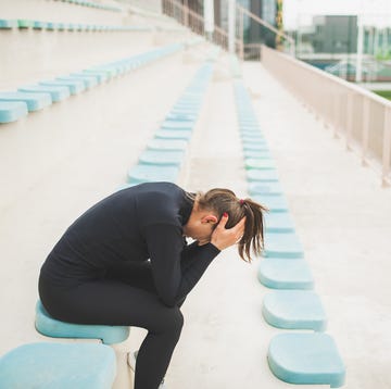 Tired and powerless woman sitting on stadium seat after hard running training tired and powerless woman sitting on stadium seat after hard running training