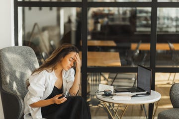 tired business woman with headache burnout in work working in cafe