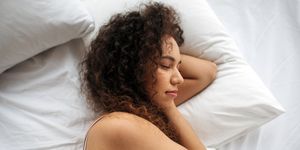 woman lying in bed tired, her eyes closed