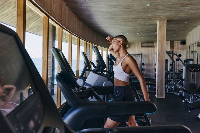 tired female athlete walking on treadmill in a gym.