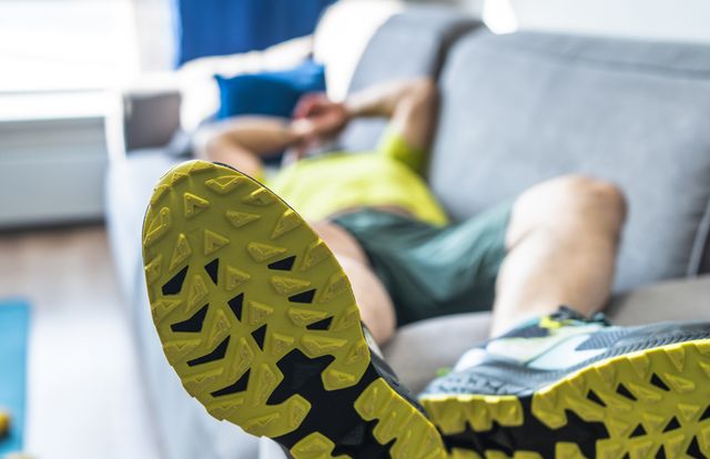 tired mature man resting on sofa after the morning workout