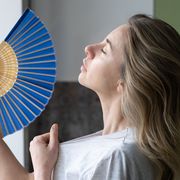 tired overheated woman using wave fan suffer from heat sweating, cools herself,  feels sluggish