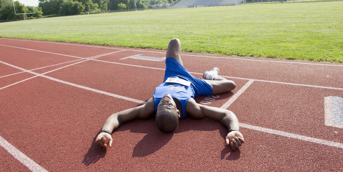tired runner laying on track after race