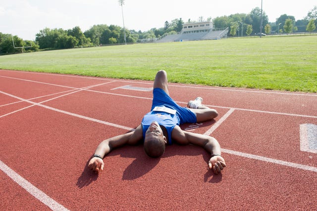 tired runner laying on track after race