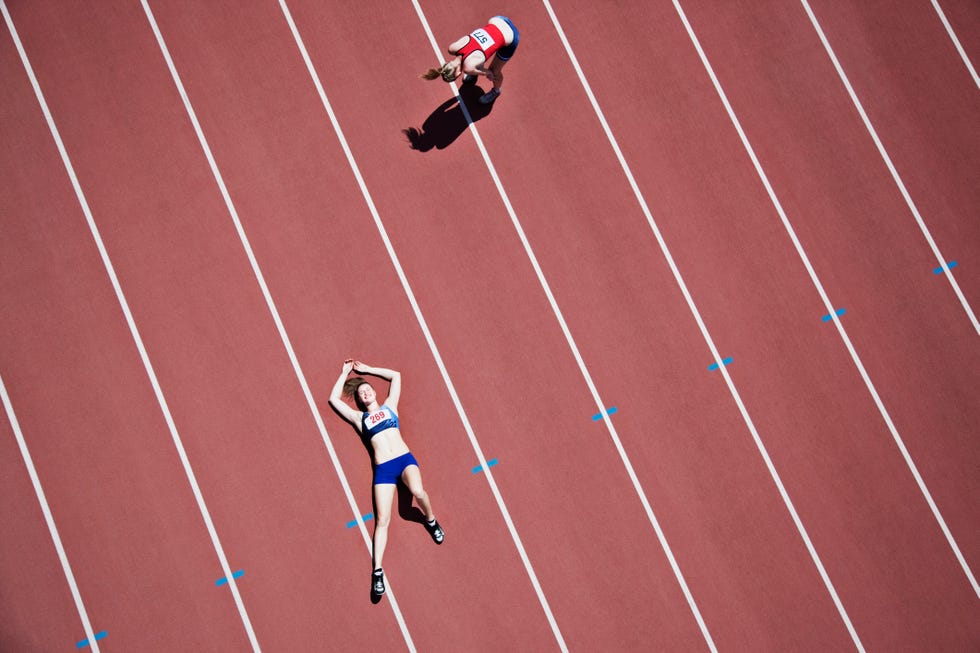 corredora tumbada en la pista de atletismo