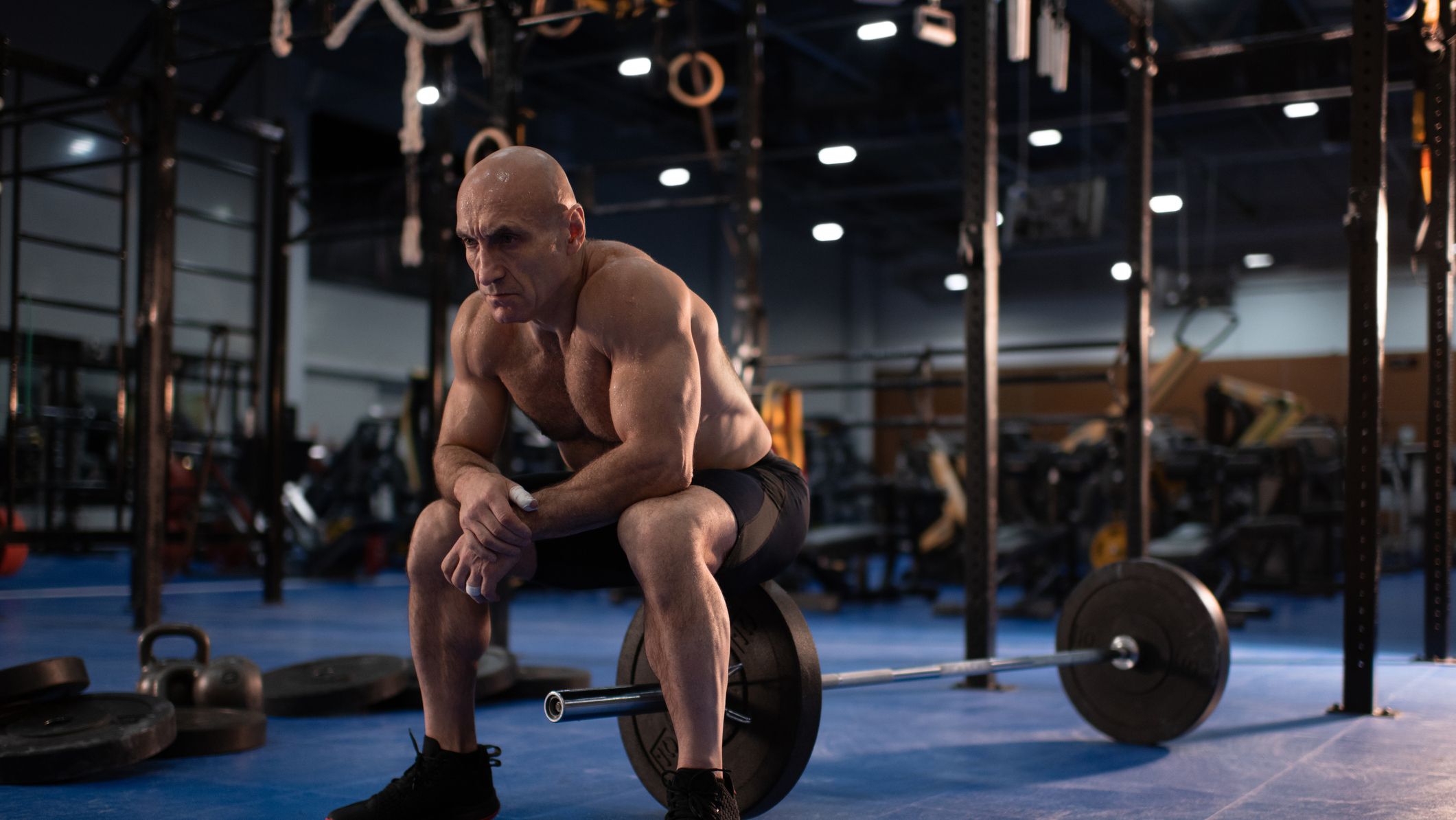 https://hips.hearstapps.com/hmg-prod/images/tired-senior-sportsman-sitting-on-barbell-royalty-free-image-1660600717.jpg?crop=1xw:0.84415xh;center,top