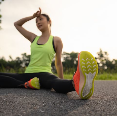 tired woman runner taking a rest after running hard in the park. sweating fitness woman tired exausted of running in sun heat dehydrated with sweat dripping from face. athlete jogger jogging outside in city.
