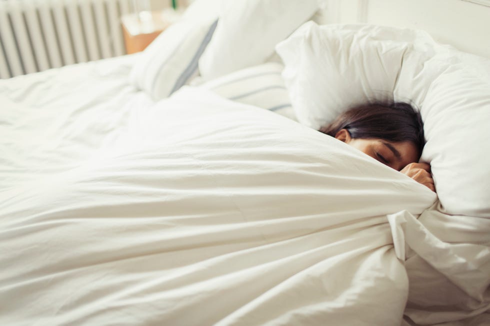 Tired young woman sleeping in bed