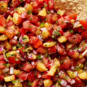 finely chopped peaches and tomatoes in a bowl with tortilla chips