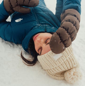 person lying in snow wearing winter clothing person lying in snow wearing winter clothing