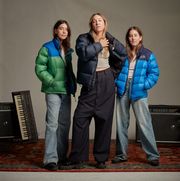 haim sisters wearing north face puffer jackets in blue, navy, and green