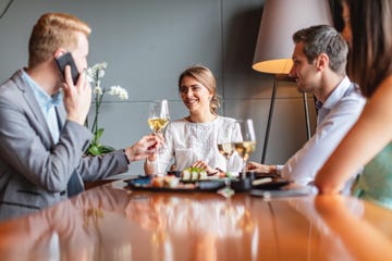Toasting with colleague while talking on smartphone