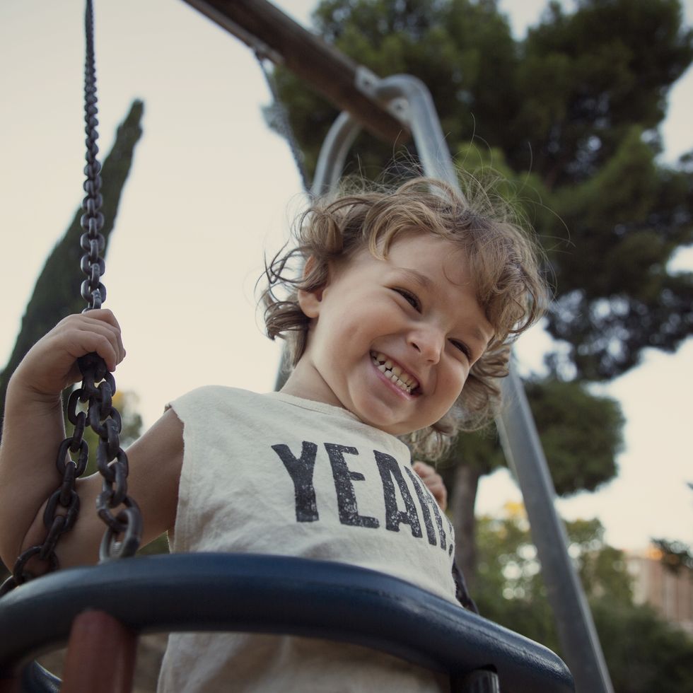 toddler at the swing laughing