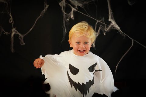 little boy in ghost costume on halloween