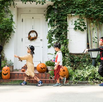kids walking past an ivy covered house in halloween costumes