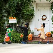 kids walking past an ivy covered house in halloween costumes