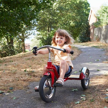 niña con triciclo rojo