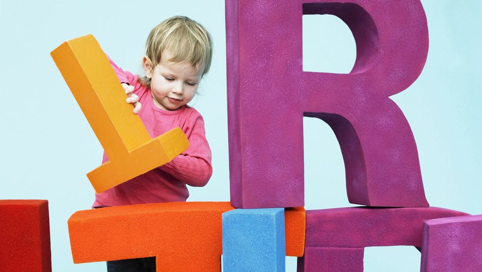 toddler playing with oversize letters