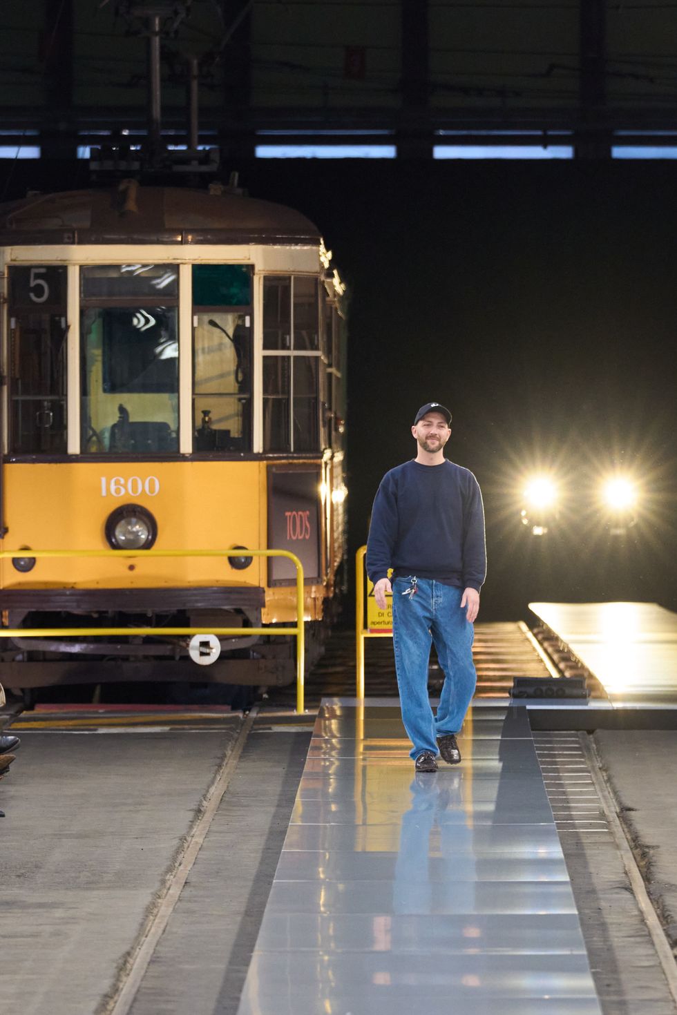a person standing on a platform next to a train at night
