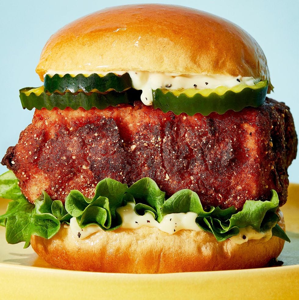 crispy tofu sandwich on a bun with lettuce, garlic mayo, and pickles