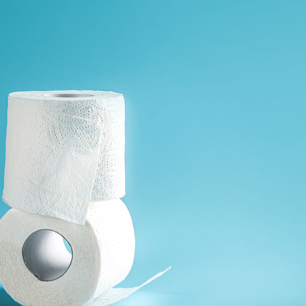 two toilet paper rolls stacked on blue background