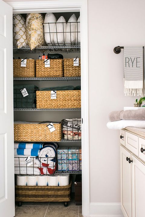 linen closet organization with toilet paper basket