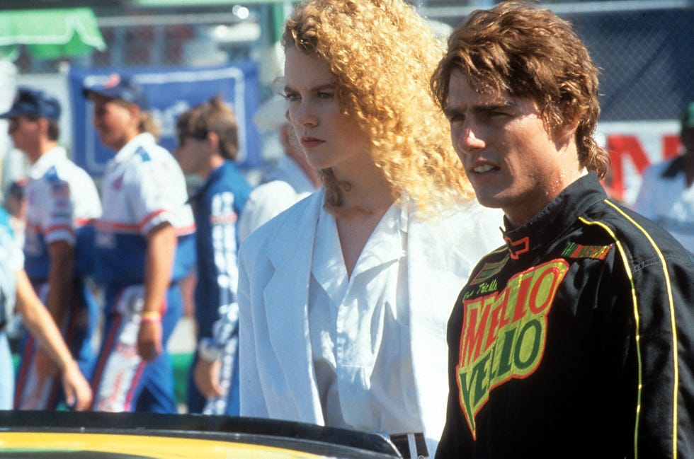 nicole kidman standing next to tom cruise behind the hood of a car