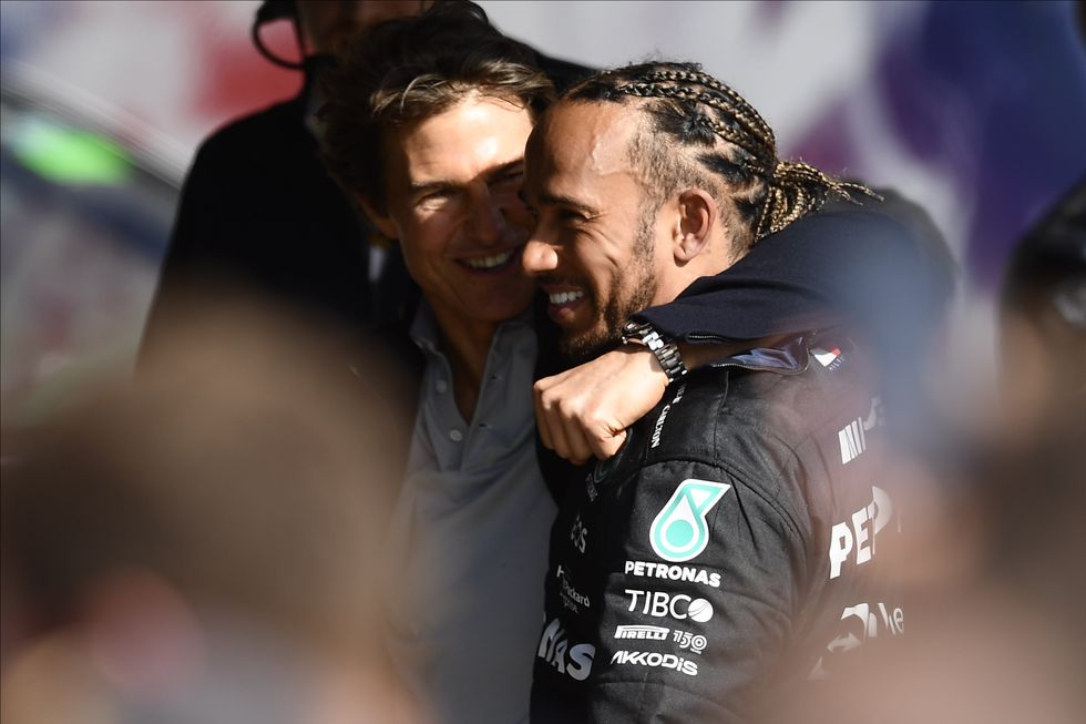 Tom Cruise y Lewis Hamilton sonríen y se abrazan en el Gran Premio de Gran Bretaña