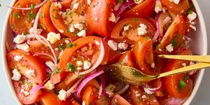 sliced tomatoes with red onions and feta and herbs