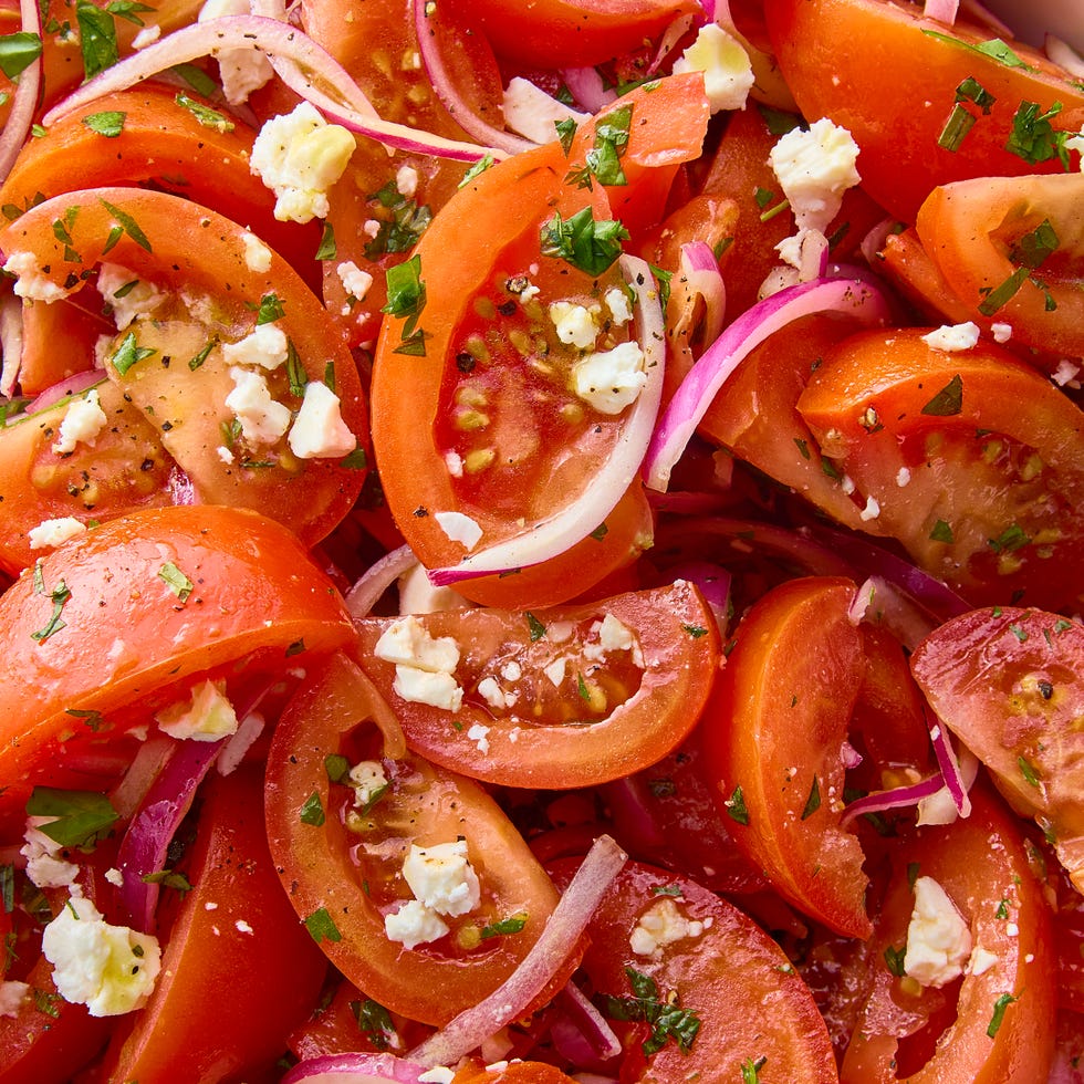 sliced tomatoes with red onions and feta and herbs