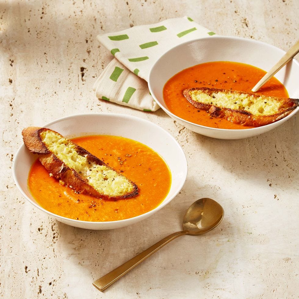 tomato soup with parmesan crostini on white table