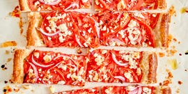tomato tart topped with red onion and crumbled feta