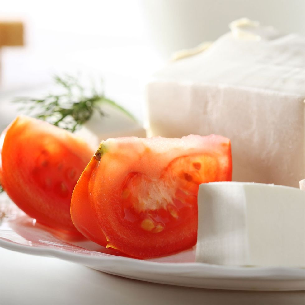 sliced tomatoes with a block of feta cheese