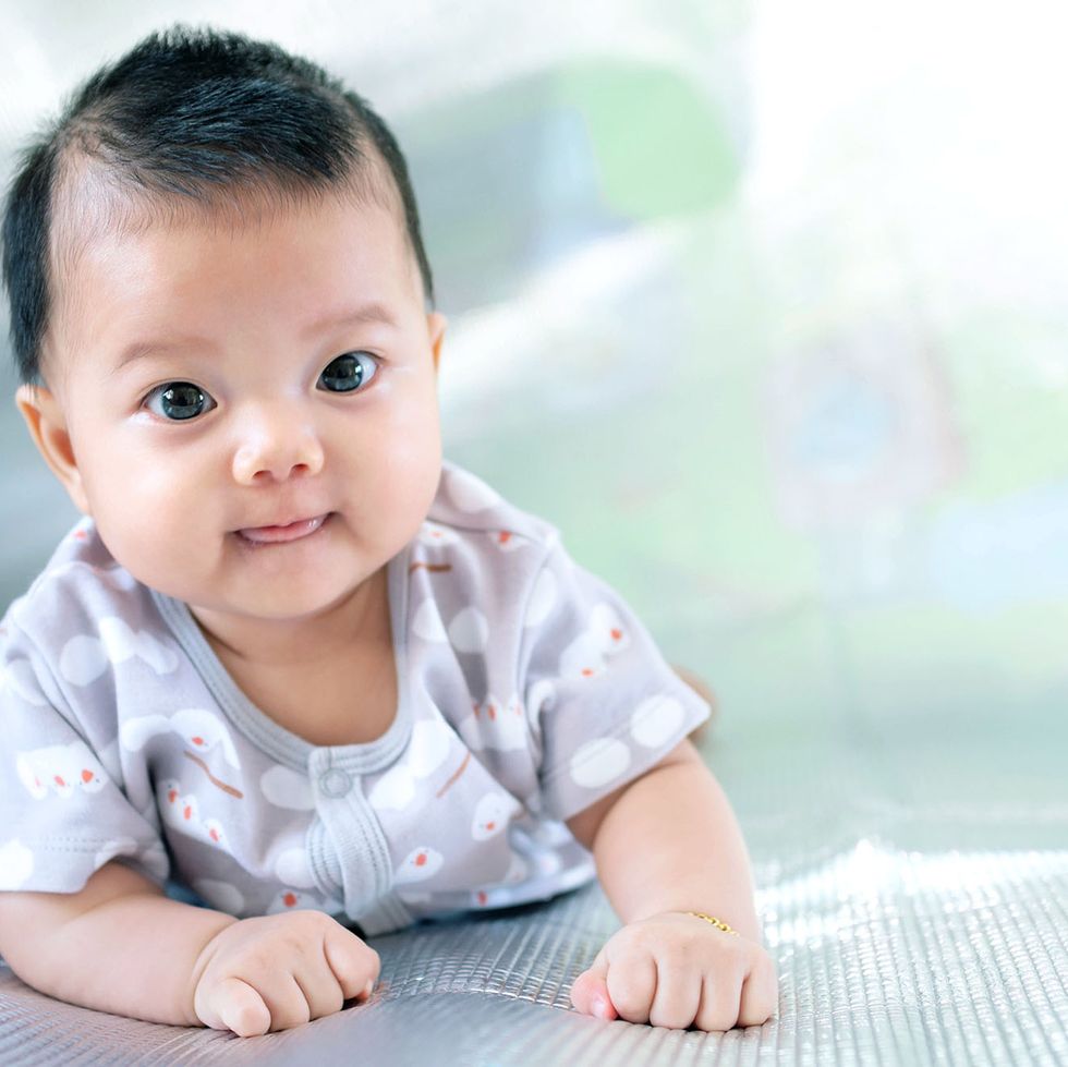 top baby boy names article shows a southeast asian new born is creeping on the floor newborn is wearing gray shirt baby is south east asian kid is cute child is taking photo indoor infant is 4 months people, health care concept