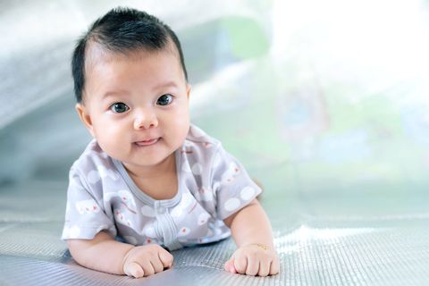 top baby boy names article shows a southeast asian new born is creeping on the floor newborn is wearing gray shirt baby is south east asian kid is cute child is taking photo indoor infant is 4 months   people, health care concept