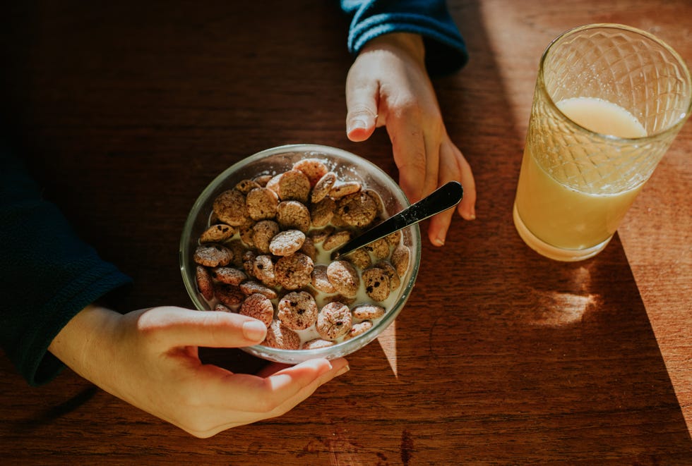 top down image of a child eating a small bowl of breakfast cereal