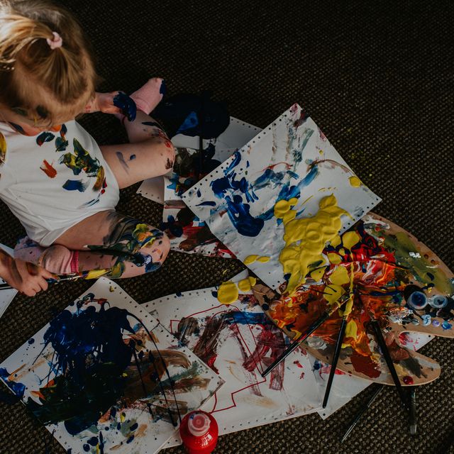 top down image of a toddler creating a huge mess with primary coloured paints