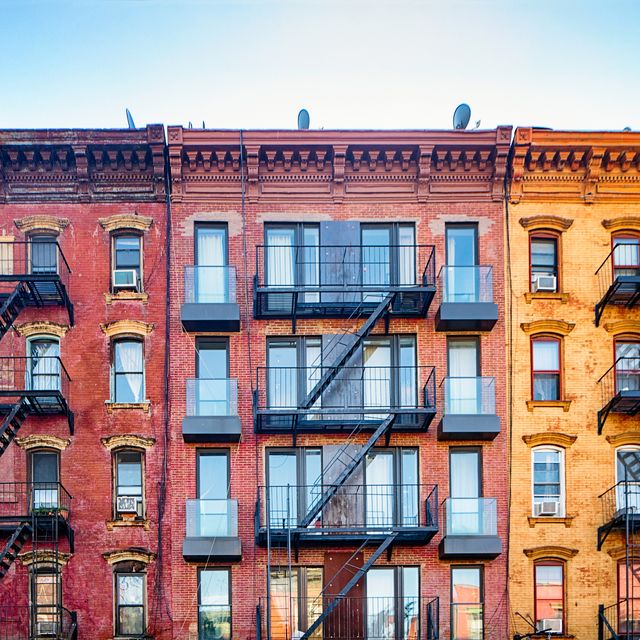 Top stories of colorful Williamsburg apartment buildings with steel fire escape stairways