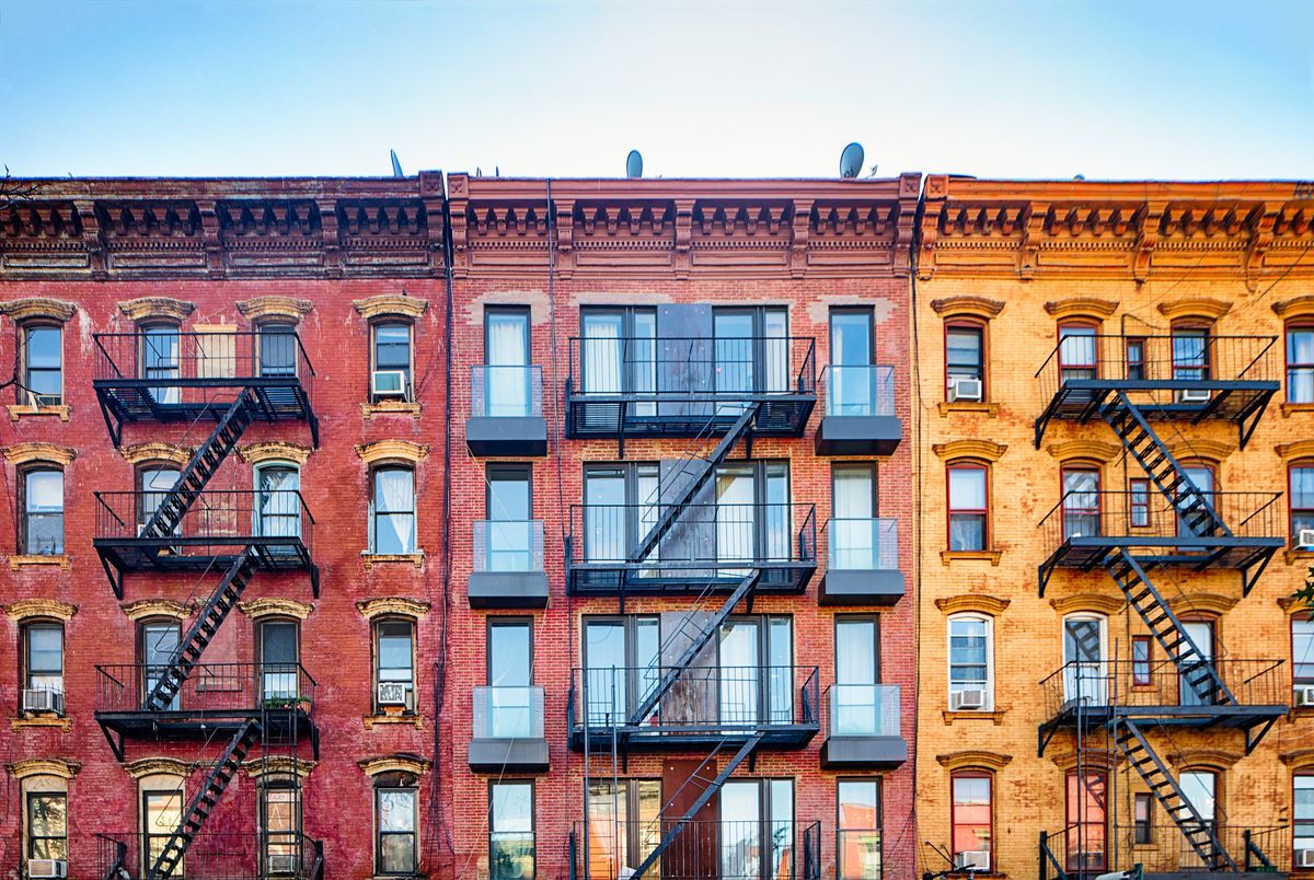 top stories of colorful williamsburg apartment buildings with steel fire escape stairways