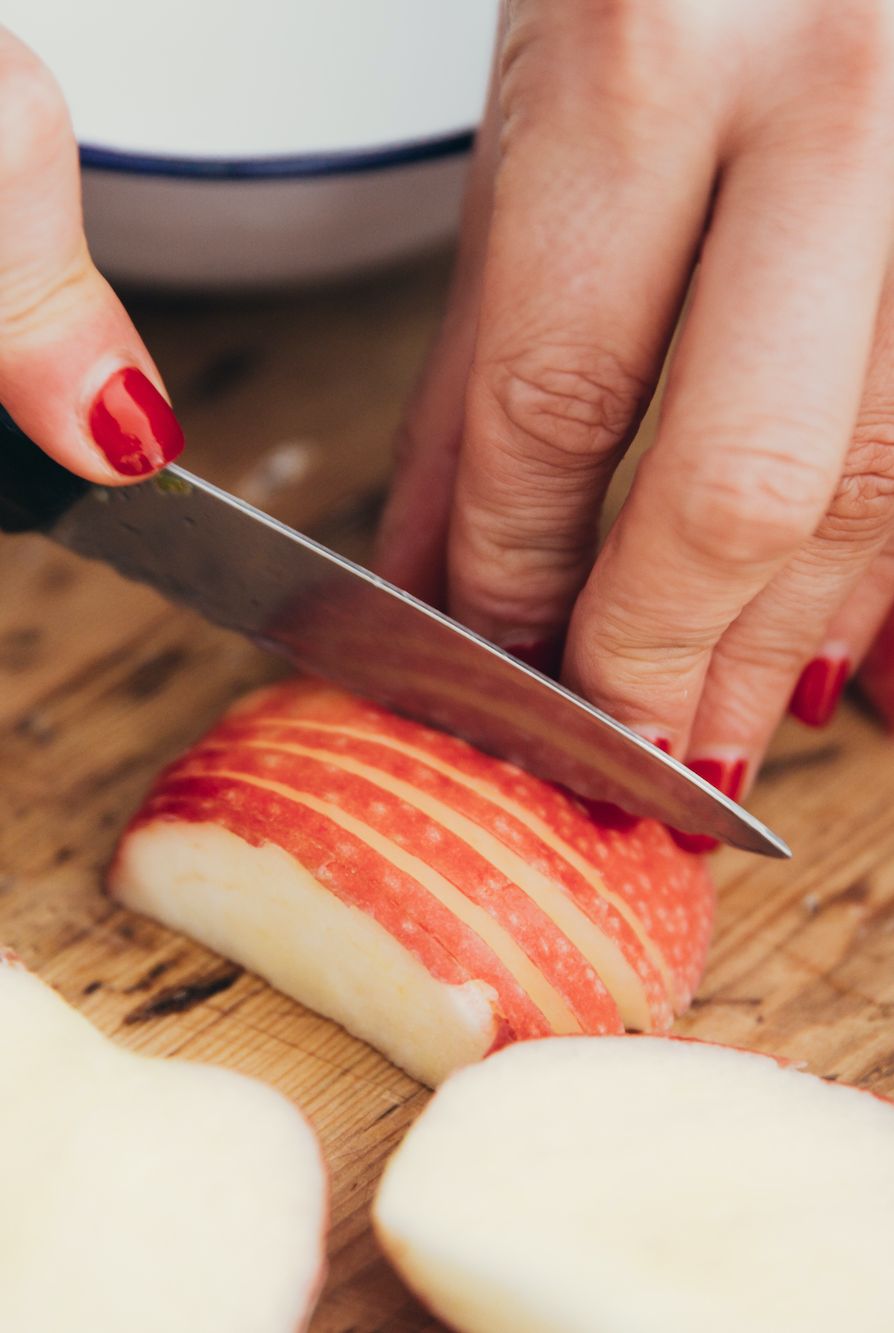 summer foods hands slicing a red apple