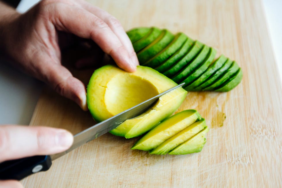 summer foods person slicing an avocado