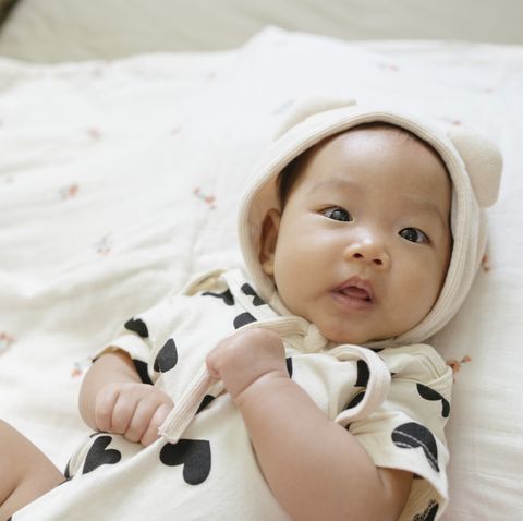 top view  facial expression asian baby girl 0 to 3 month dress up very cute on cozy bed and clear background